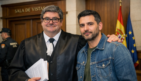 Abogado con toga en juzgado junto a cliente antes de entrar en sala por delito de coacciones en Sevilla