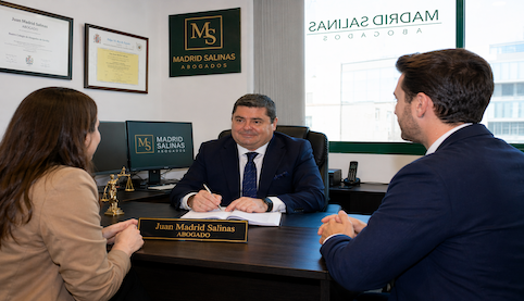 Juan Madrid Salinas, abogado de Madrid Salinas Abogados, atendiendo una reunión con clientes en el despacho sobre una herencia y su partición.