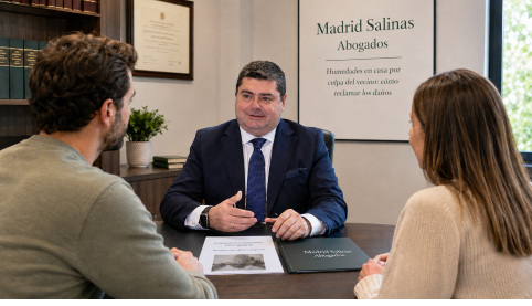 Abogado civil de Madrid Salinas Abogados asesorando a clientes en un despacho sobre una reclamación por humedades y filtraciones causadas por un vecino.