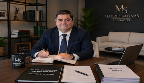 Abogado de familia en Sevilla revisando un expediente sobre pensión de alimentos de hijo mayor de edad en el despacho Madrid Salinas Abogados.